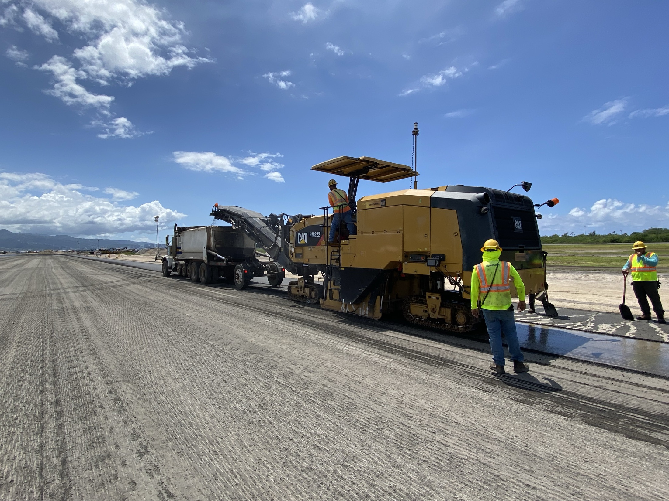 Large milling machine and crew working on runway surface preparation